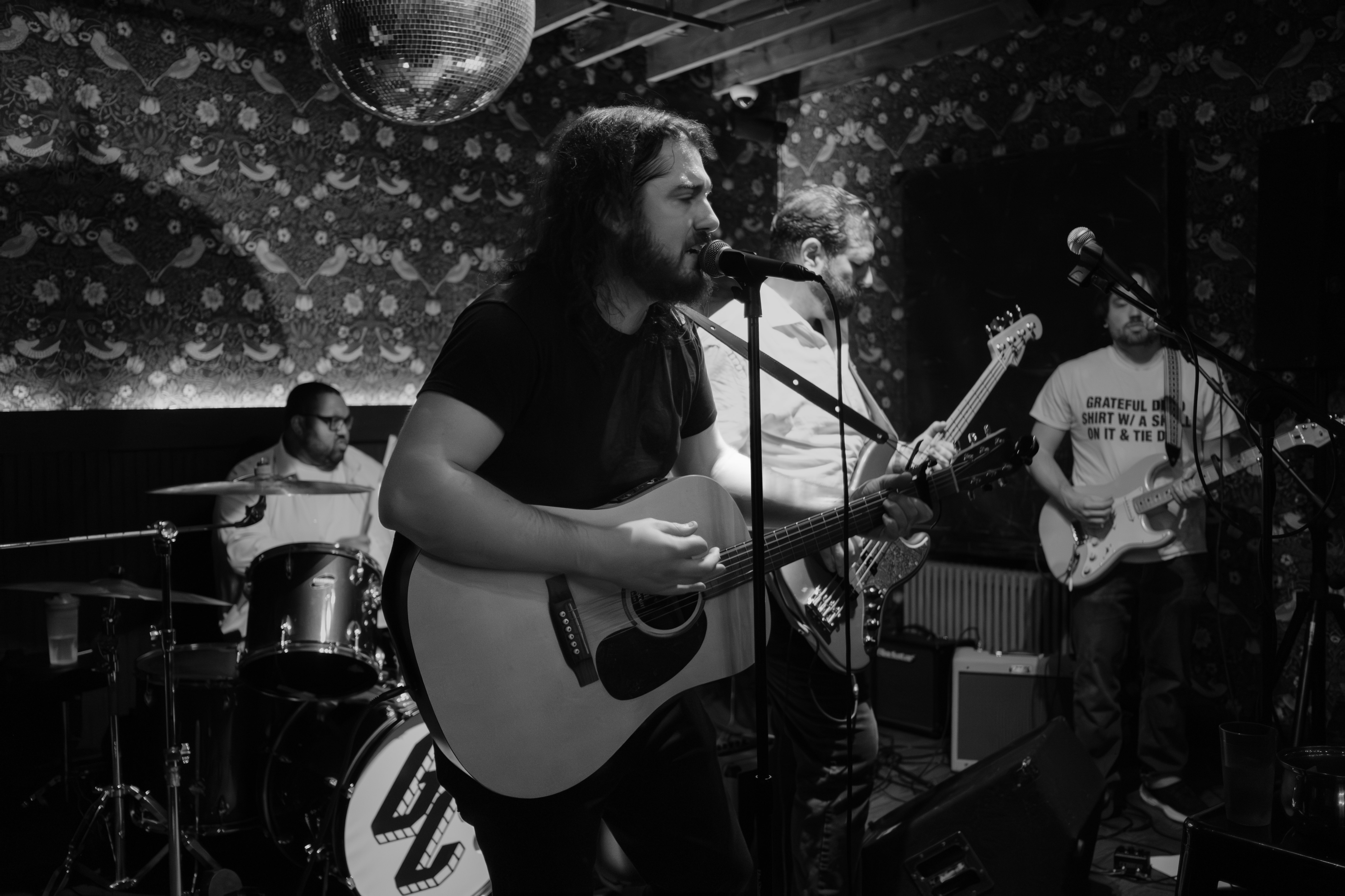 B&W vocalist with acoustic guitar singing