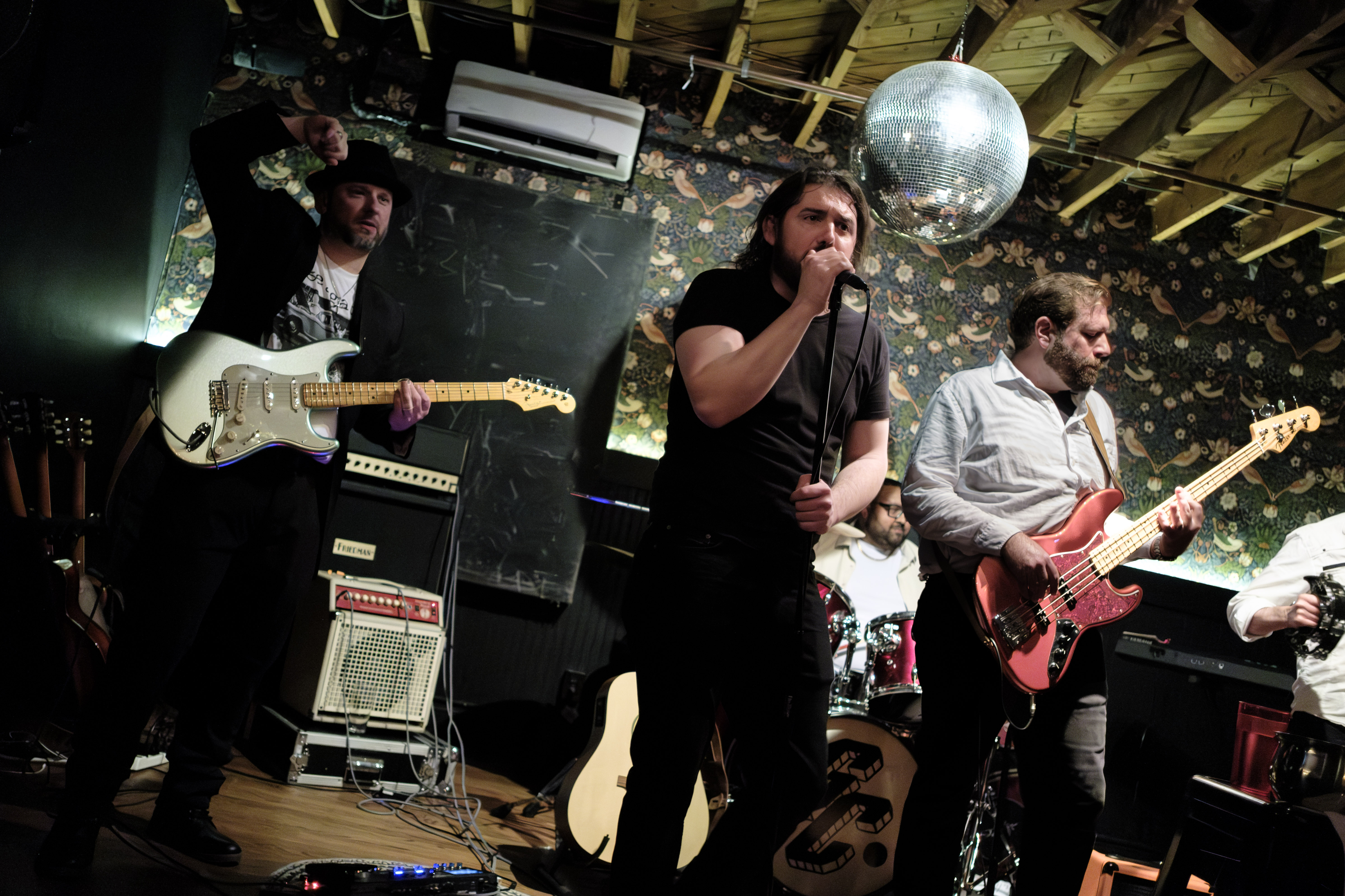 Action shot, guitarist, vocalist, bassist in tight formation